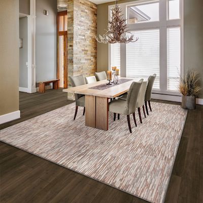 patterned area rug in a rustic dining room  with wood flooring